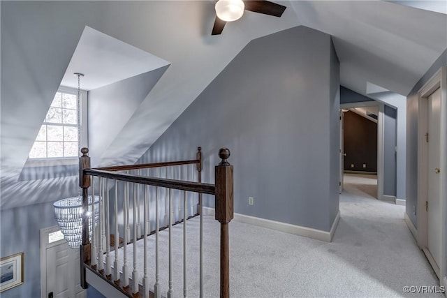 stairs with carpet flooring, ceiling fan with notable chandelier, and vaulted ceiling