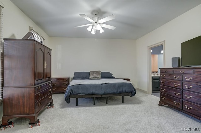 bedroom with connected bathroom, ceiling fan, and light colored carpet