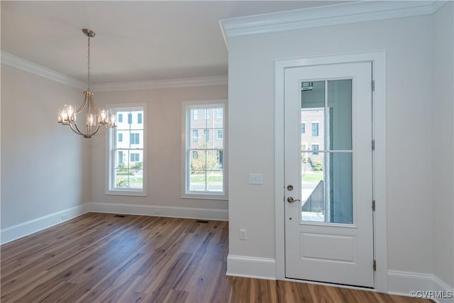 foyer featuring crown molding, dark hardwood / wood-style flooring, and a notable chandelier