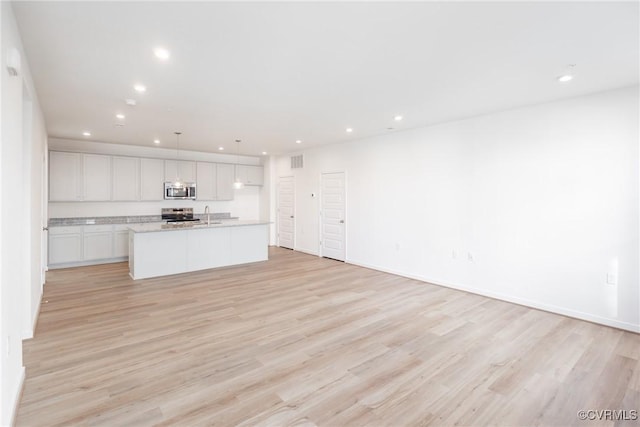 unfurnished living room featuring light hardwood / wood-style floors and sink