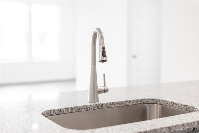 details featuring light stone countertops and sink