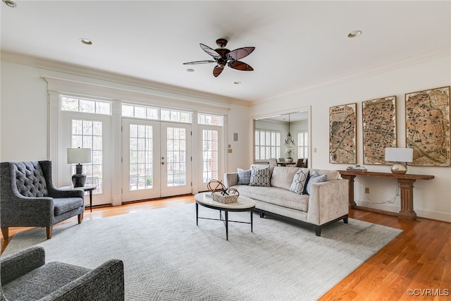 living room with ornamental molding, a healthy amount of sunlight, and wood-type flooring