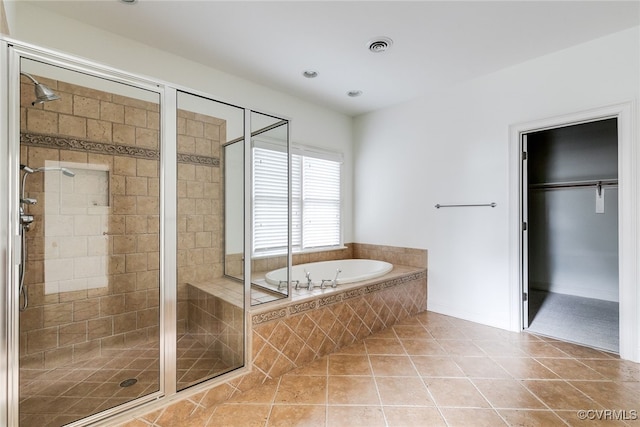 bathroom with tile patterned flooring and shower with separate bathtub