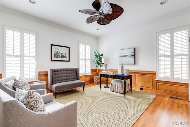 office featuring crown molding, ceiling fan, a healthy amount of sunlight, and wood-type flooring