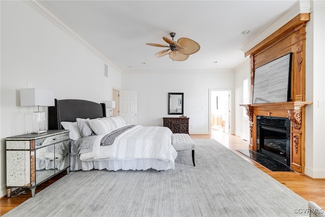 bedroom with ceiling fan, light hardwood / wood-style floors, and ornamental molding