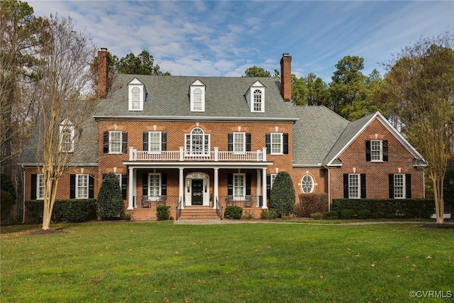 colonial inspired home featuring a front yard and covered porch