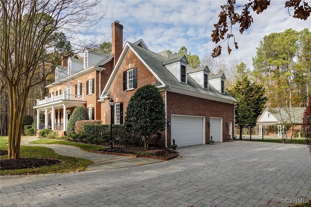 view of side of property featuring a garage and a balcony