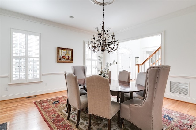 dining area featuring plenty of natural light, wood-type flooring, and ornamental molding