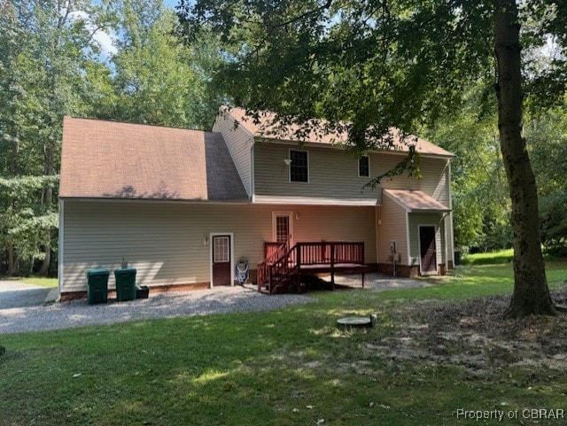 back of property with a yard and a deck