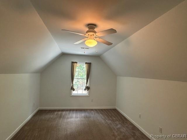 additional living space with ceiling fan, dark carpet, and vaulted ceiling