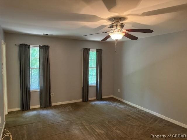 carpeted empty room featuring ceiling fan and a wealth of natural light