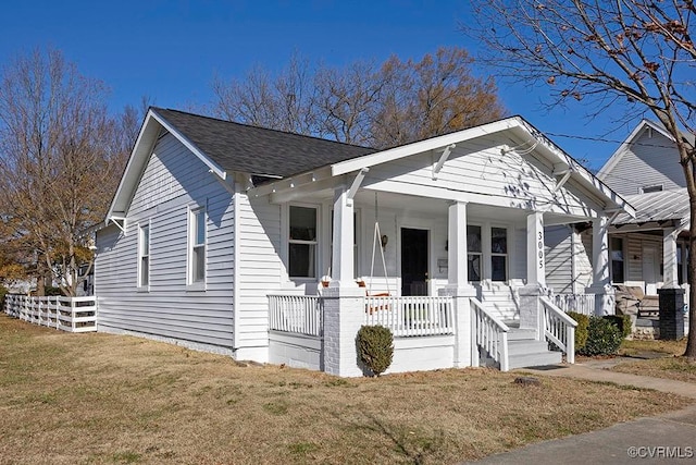 view of front of house featuring covered porch and a front yard