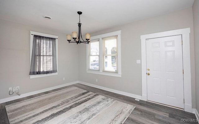 interior space featuring dark hardwood / wood-style flooring and an inviting chandelier