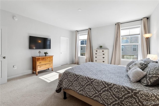 bedroom featuring light colored carpet and multiple windows