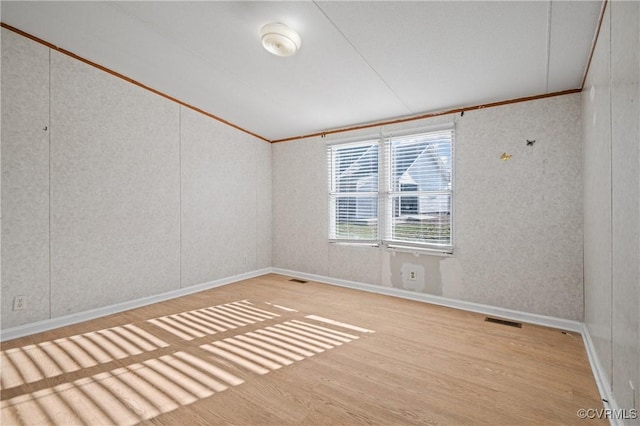 unfurnished room with wood-type flooring and crown molding