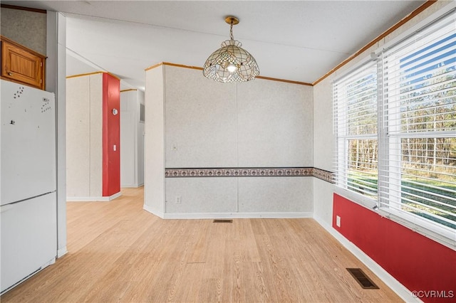 interior space featuring crown molding and light hardwood / wood-style flooring