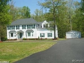 view of front of property featuring an outbuilding, a front yard, and a garage