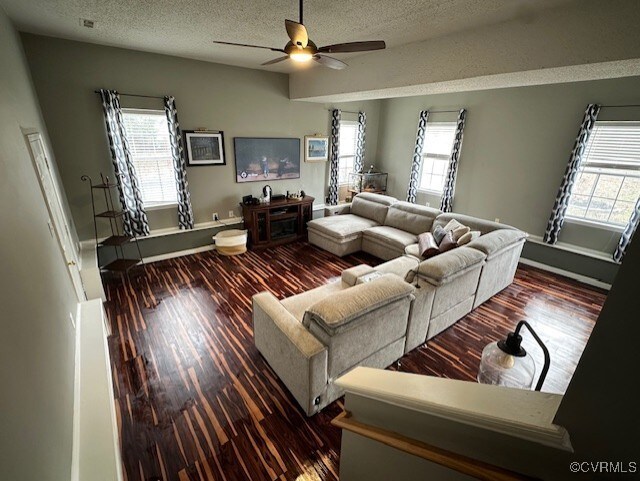 living room featuring a textured ceiling, dark hardwood / wood-style flooring, and ceiling fan