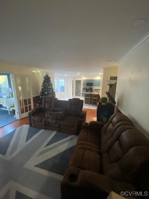 living room with crown molding, a healthy amount of sunlight, and hardwood / wood-style flooring