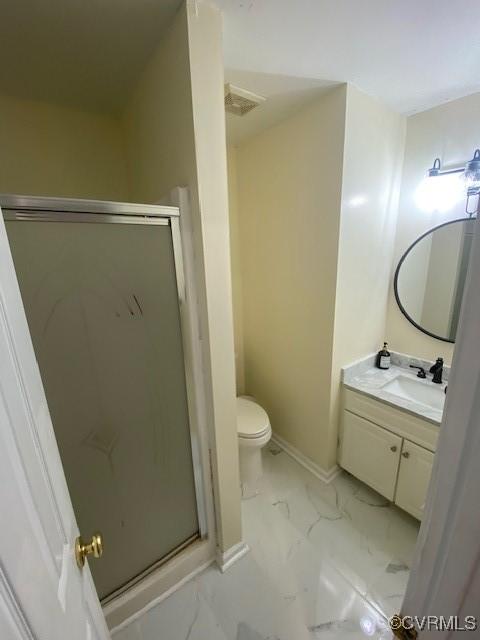 bathroom featuring vanity, toilet, and a shower with door