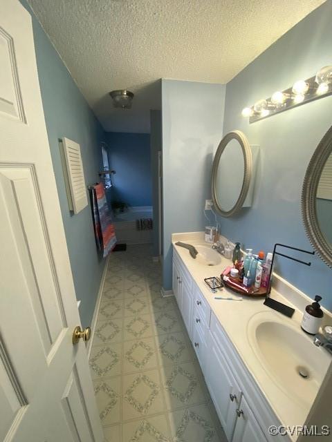 bathroom featuring a textured ceiling and vanity