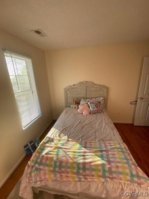 bedroom featuring dark hardwood / wood-style floors and a textured ceiling