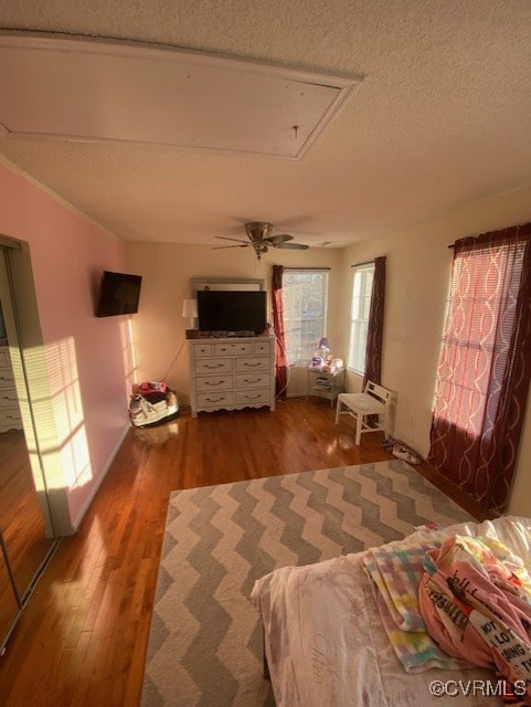 bedroom featuring hardwood / wood-style flooring, ceiling fan, and a textured ceiling