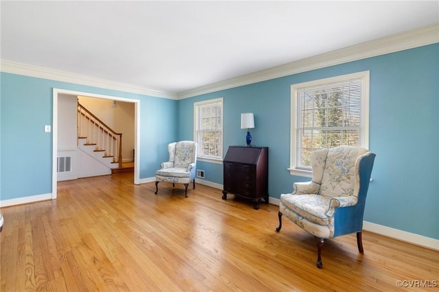 living area featuring light wood-type flooring and crown molding