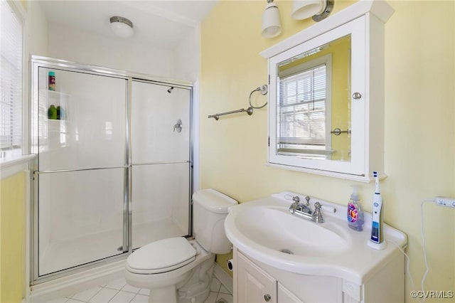 bathroom featuring tile patterned floors, a shower with door, vanity, and toilet