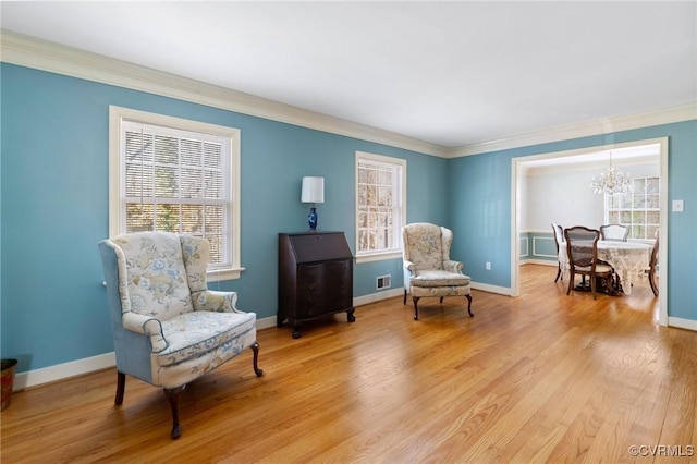 sitting room featuring crown molding, light hardwood / wood-style flooring, and a healthy amount of sunlight