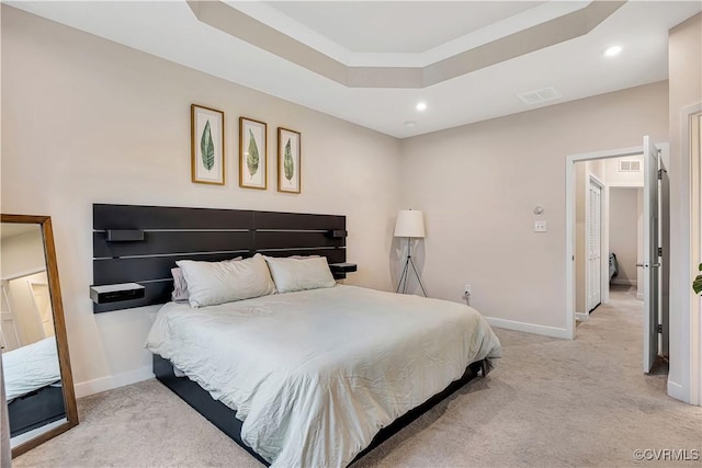 carpeted bedroom with a tray ceiling