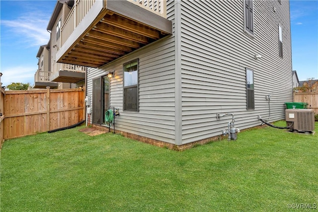 view of side of property featuring central AC and a yard