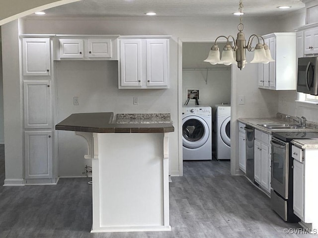 kitchen with a kitchen bar, white cabinets, and washer and dryer