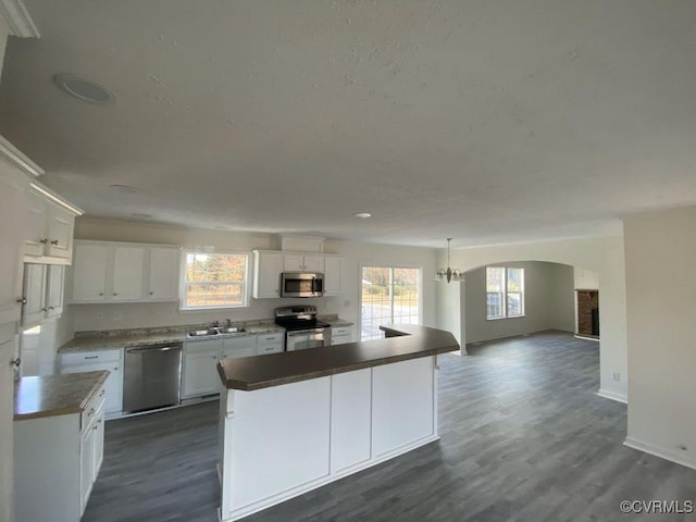 kitchen with appliances with stainless steel finishes, white cabinetry, and plenty of natural light