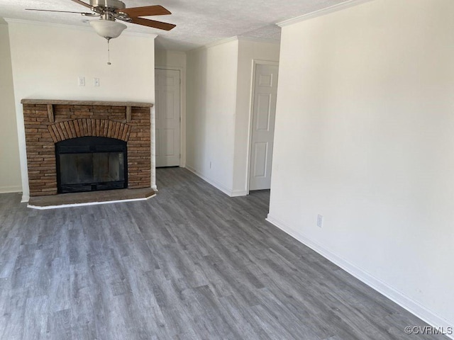 unfurnished living room with hardwood / wood-style floors, ceiling fan, crown molding, and a brick fireplace