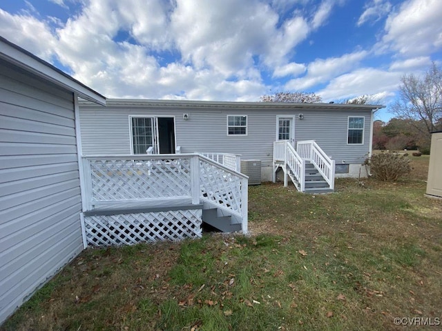 rear view of house with a lawn and central AC