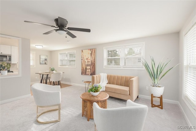 carpeted living room with ceiling fan and a healthy amount of sunlight