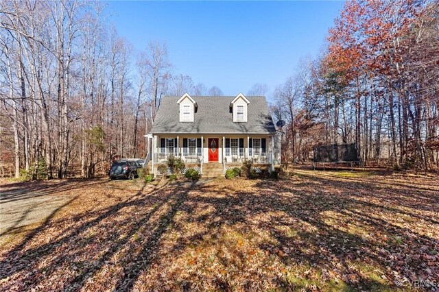 cape cod home featuring a porch and a trampoline