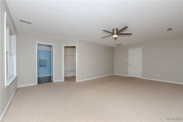 10710 Courthouse Rd, Dinwiddie, VA 23841 - unfurnished bedroom featuring ensuite bathroom, a textured ceiling, ceiling fan, a spacious closet, and carpet floors