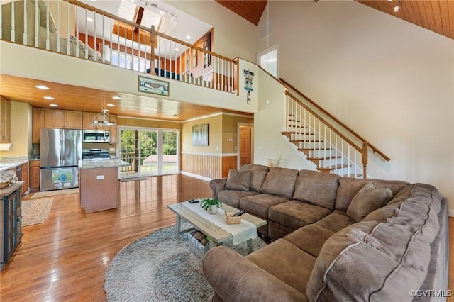 living room with light hardwood / wood-style flooring, high vaulted ceiling, and wood ceiling