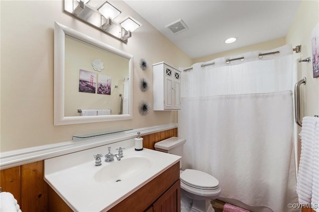 bathroom featuring curtained shower, vanity, and toilet