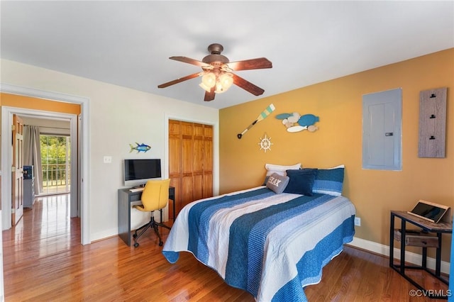 bedroom featuring hardwood / wood-style floors, ceiling fan, electric panel, and a closet