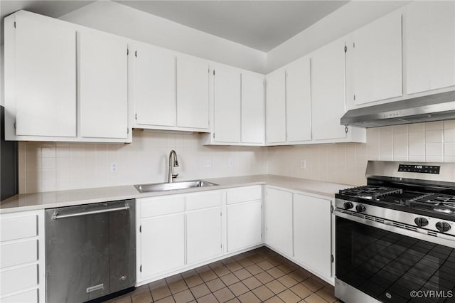 kitchen featuring white cabinets, stainless steel appliances, dark tile patterned floors, and sink