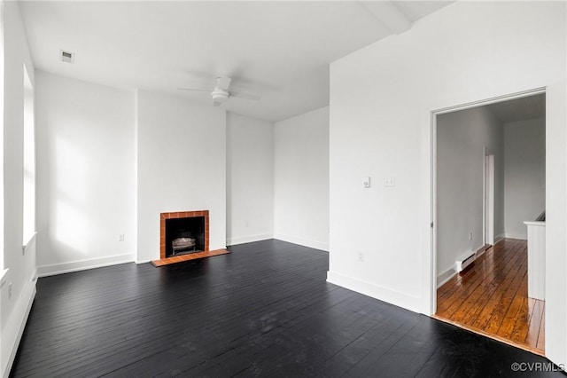 unfurnished living room with a fireplace, beam ceiling, dark hardwood / wood-style floors, and ceiling fan