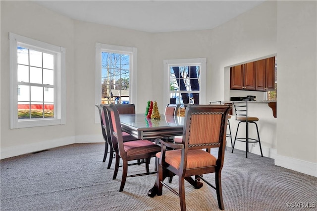 carpeted dining space featuring plenty of natural light