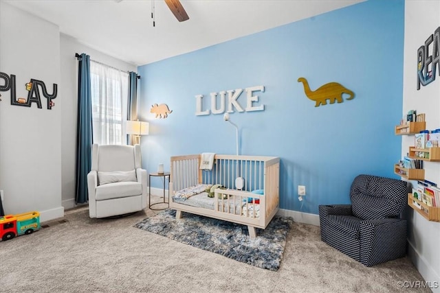 carpeted bedroom with a nursery area and ceiling fan