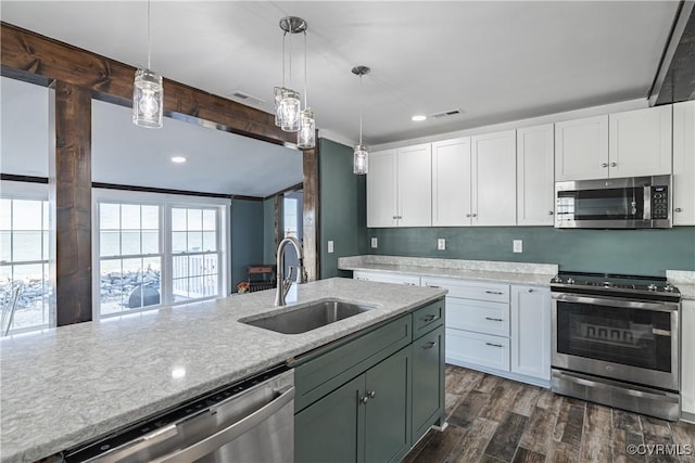 kitchen featuring stainless steel appliances, dark wood-type flooring, sink, pendant lighting, and white cabinetry