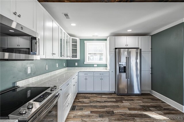 kitchen featuring dark hardwood / wood-style floors, light stone countertops, white cabinetry, and stainless steel appliances