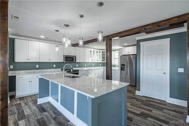 kitchen featuring appliances with stainless steel finishes, sink, a large island with sink, pendant lighting, and white cabinetry