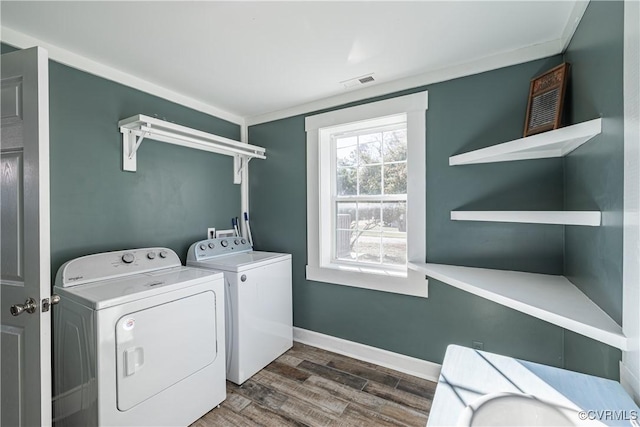 laundry room with washer and clothes dryer and dark wood-type flooring